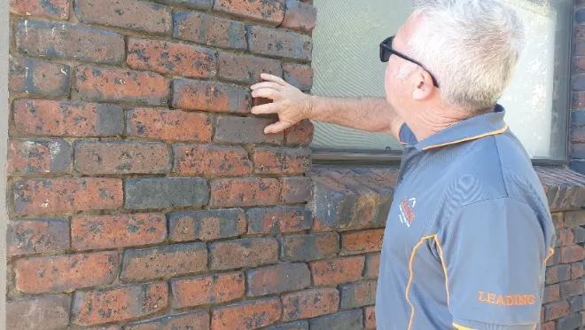 Licensed building inspector conducting a pre-purchase inspection